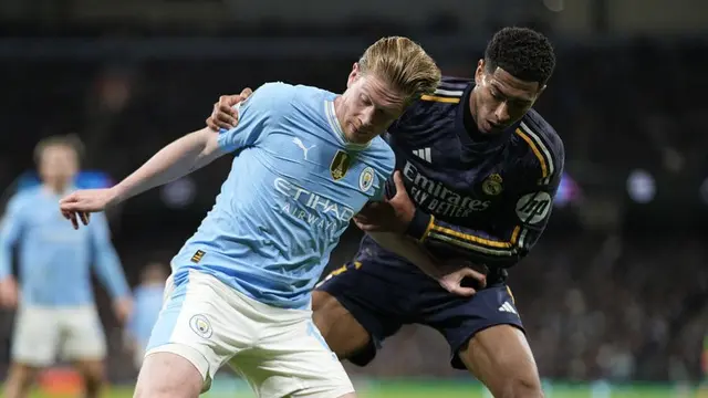 Kevin de Bruyne dikawal Jude Bellingham dalam laga Manchester City vs Real Madrid di Liga Champions 2023/2024, Kamis (18/4/2024) dini hari WIB. (c) AP Photo/Dave Shopland