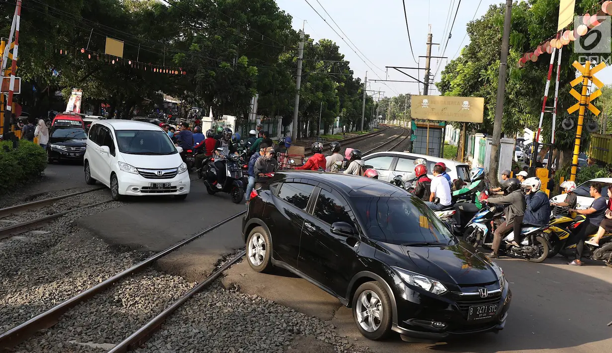 Kendaraan melintasi perlintasan kereta api di kawasan Lenteng Agung, Jakarta, Kamis (14/3). Pembangunan fly over berbentuk tapal kuda tersebut diprediksi akan mengurangi tingkat kemacetan antara 40-50 persen. (Liputan6.com/Immanuel Antonius)