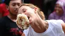 Salah satu warga negara asing saat mengikuti lomba makan kerupuk di kawasan Jalan Jaksa, Jakarta, Kamis (17/8). Lomba diadakan untuk memeriahkan HUT RI ke-72. (Liputan6.com/Helmi Fithriansyah)