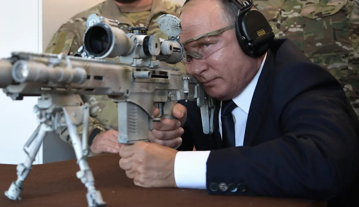 Presiden Rusia, Vladimir Putin menguji coba senapan sniper Chukavin (SVC-380) saat mengunjungi pameran Kalashnikov Concern di Patriot Park, luar Moskow, Rabu (19/9). Kalashnikov merupakan produsen senjata terkenal di dunia. (Alexey NIKOLSKY/SPUTNIK/AFP)