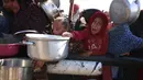 Serangan militer Israel di Gaza juga telah menimbulkan beragam krisis kemanusiaan. Tampak dalam foto, warga Palestina berdiri menunggu pembagian makanan di pusat distribusi di selatan Khan Yunis di Jalur Gaza selatan pada 17 Desember 2024. (BASHAR TALEB/AFP)