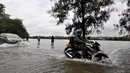 Curah hujan yang tinggi menyebabkan Danau Sunter tak mampu menampung debit air hingga meluap ke daerah sekitarnya. Tampak sejumlah kendaraan nekat menerobos banjir, Jakarta, Selasa (10/2/2015). (Liputan6.com/Faizal Fanani)