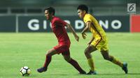 Pemain depan Timnas Indonesia U-19. Hanis Saghara Putra (kiri) mencoba melewati pemain China U-19, Ao Chen pada PSSI 88th U-19 International Tournament di Stadion Pakansari, Selasa (25/9). Indonesia kalah 0-3. (Liputan6.com/Helmi Fithriansyah)
