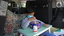 Seorang siswa TK membuat miniatur bedug saat mengikuti proses pembelajaran secara Drive in Learning di area parkir Padepokan Pencak Silat Indonesia, Jakarta, Kamis (8/4/2021). Kegiatan ini juga untuk menyambut Ramadan dengan penuh rasa syukur dan kebahagiaan. (Liputan6.com/Herman Zakharia)