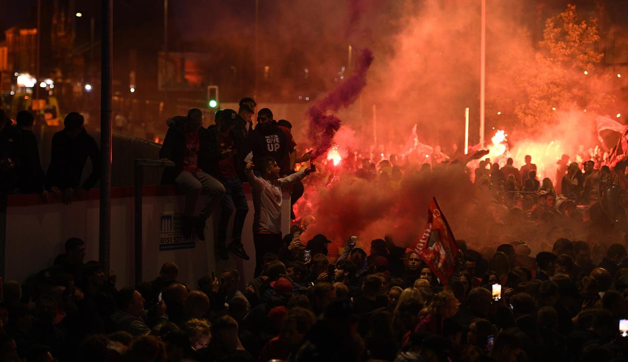 Fans Liverpool merayakan gelar juara Premier League di area Standion Anfield usai pertandingan Liverpool melawan Chelsea, Kamis (23/7/2020) dini hari WIB. Fans Liverpool tetap berdatangan ke area Stadion Anfield meski ada permintaan untuk merayakan di rumah. (AFP/Oli Scarff)