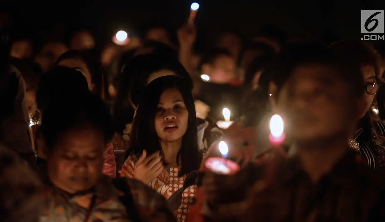 Jemaat menyalakan lilin dalam acara Natal Taruna Merah Putih di Jakarta, Jumat (22/12). Natal 2017 mengusung tema 'Konser Bersama Tuhan Yesus di Danau Toba' (Liputan6.com/Faizal Fanani)