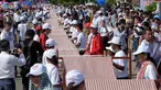 Warga Kamboja membentangkan syal krama sepanjang 1.149,8 meter untuk memecahkan rekor Guinness sebagai syal tenun terpanjang dunia di Phnom Penh, Minggu (1/7). Lebih dari 23.000 orang berpartisipasi membentangkan syal tersebut. (AFP/TANG CHHIN Sothy)