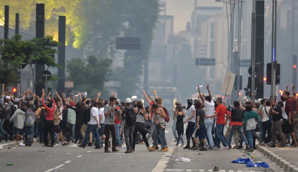 Mahasiswa bentrok dengan polisi saat memprotes kenaikan tarif bus di Sao Paulo, Brasil, Selasa (12/1). Mereka protes karena di tengah krisis ekonomi yang ditandai dan inflasi tinggi, tarif transportasi angkutan bus justru naik. (AFP PHOTO/NELSON Almeida)