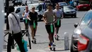 Orang-orang beraktivitas menggunakan skuter listrik di Paris, Prancis (9/7). Skuter listrik ini dibuat oleh perusahaan AS Lime yang merupakan penyewaan transportasi sepeda dan skuter di berbagai kota. (AFP Photo/Francois Guillot)