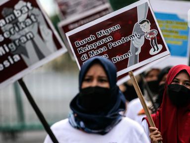 Aktivis yang tergabung dalam Serikat Buruh Migran Indonesia (SBMI) melakukan aksi damai di Kawasan Monas, Jakarta Pusat, Minggu (13/3/2022). Aksi yang diikuti oleh para pekerja perempuan dan mahasiswa ini dilakukan untuk memperingati hari Perempuan Sedunia. (Liputan6.com/Johan Tallo)
