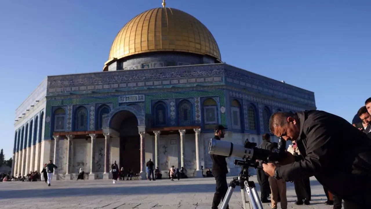 Seorang pria menggunakan teleskop saat mencari bulan sabit untuk menandai dimulainya bulan suci Ramadan di kompleks Masjid Al-Aqsa, Yerusalem, pada 28 Februari 2025.