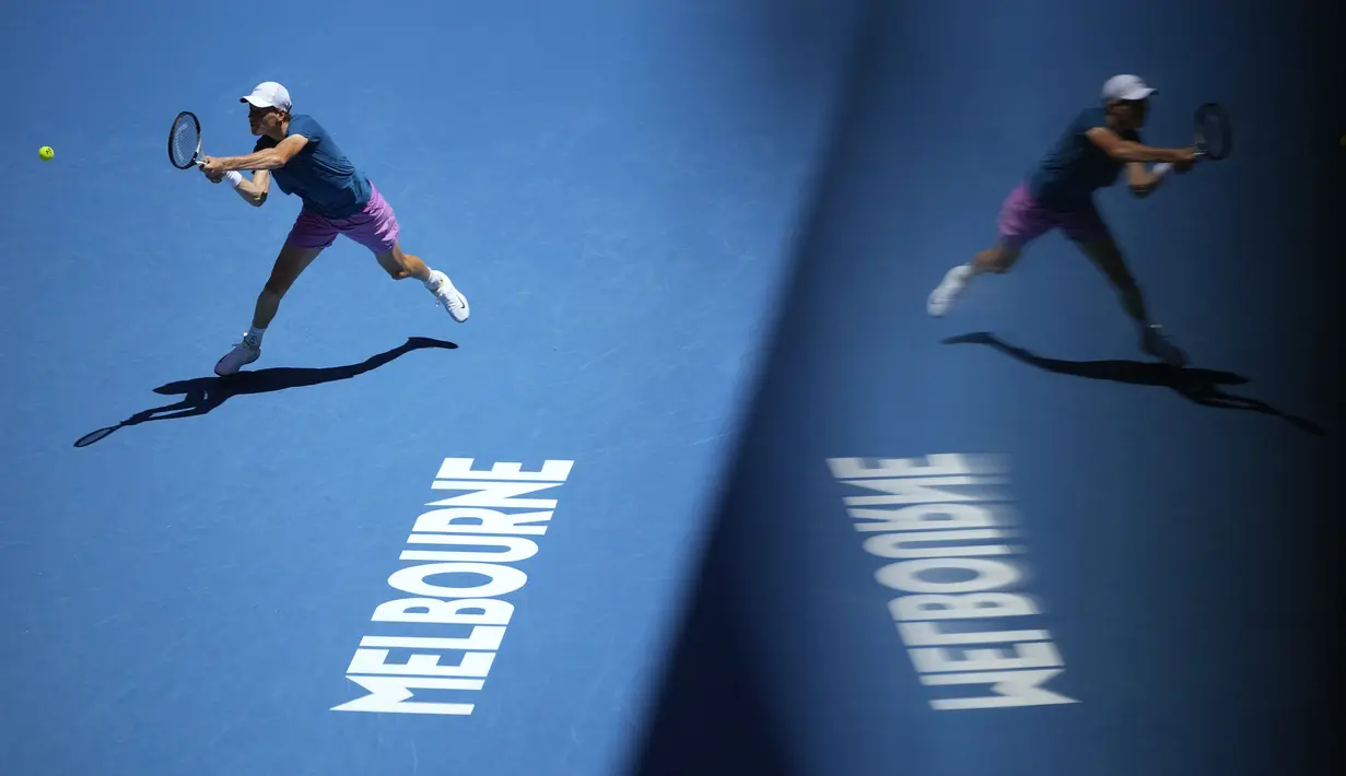 Petenis Italia, Jannik Sinner mengembalikan bola ke arah petenis Hungaria, Marton Fucsovics saat laga putaran ketiga Australian Open 2023 di Melbourne, Australia, Jumat (20/01/2023). (AP Photo/Dita Alangkara)