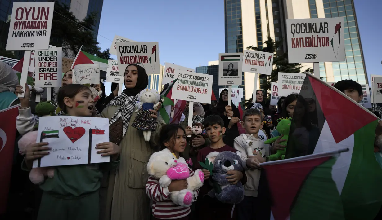 Para pengunjuk rasa memegang mainan dan meneriakkan slogan-slogan selama unjuk rasa pro-Palestina, di Istanbul, Turki, Sabtu, 21 Oktober 2023. (AP Photo/Khalil Hamra)