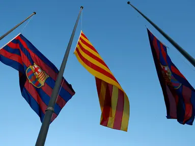 Untuk mengenang Tito Vilanova, di Stadion Camp Nou, Barcelona (25/4/2014), bendera Barcelona dan Catalunya dikibarkan setengah tiang. (REUTERS/Albert Gea)