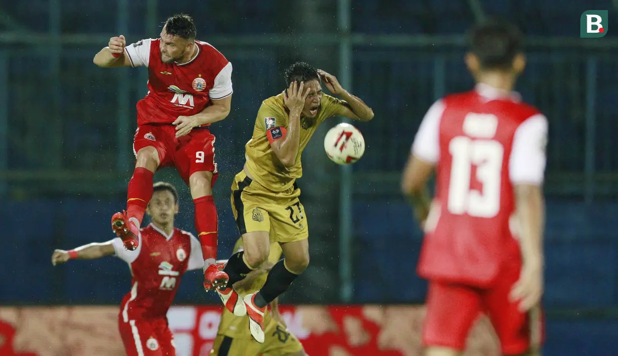 Striker Persija Jakarta, Marko Simic (kiri) duel udara dengan pemain Bhayangkara Solo FC, Indra Kahfi, pada laga Piala Menpora 2021 di Stadion Kanjuruhan, Malang, Rabu (31/3/2021). Persija Menang dengan skor 2-1. (Bola.com/M Iqbal Ichsan)