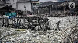 Suasana jembatan kayu di antara sampah di perkampungan nelayan Cilincing, Jakarta, Minggu (21/2/2022). Peringatan HPSN 2022, Pemprov DKI Jakarta mengajak warga Jakarta untuk peduli sampah mulai dari lingkungan terdekat minimal dengan cara memilah sampah dari rumah. (Liputan6.com/Faizal Fanani)