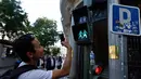 Pejalan kaki mengambil gambar lampu lalu lintas berlambang LGBT di Madrid, Spanyol, Selasa (6/6). Kota Madrid meluncurkan sekitar 300 unit lampu isyarat pejalan kaki berlambang pasangan sesama jenis untuk menyambut Festival WorldPride (OSCAR DEL POZO/AFP)
