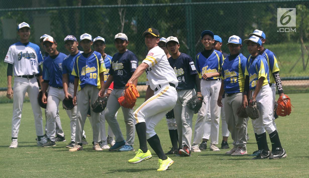 Atlet Baseball dari tim Softbank Hawks, Shuhei Fukuda memberikan contoh melempar saat Asia Baseball Clinic di Lapangan Baseball GBK, Jakarta, Rabu (19/12). Program ini untuk meningkatkan skill atlet Baseball di Indonesia. (Liputan6.com/Helmi Fithriansyah)