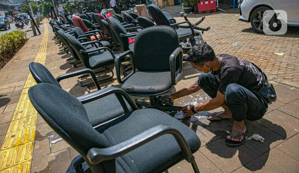 Karyawan membersihkan peralatan kantor pascabanjir di salah satu bank swasta di Kemang, Jakarta, Selasa (23/2/2021). Karyawan pertokoan, perkantoran, hingga perbankan mulai membersihkan sisa lumpur dari banjir yang melanda kawasan tersebut pada 20 Februari 2021 lalu. (Liputan6.com/Faizal Fanani)