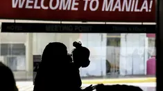 Seorang penumpang asing yang mengenakan masker tiba di Bandara Internasional Manila, Filipina, Kamis (10/2/2022). Filipina mulai hari ini membuka kembali pintu bagi turis asing yang telah divaksinasi penuh Covid-19 setelah hampir dua tahun menutup perbatasannya. (AP Photo/Basilio Sepe)