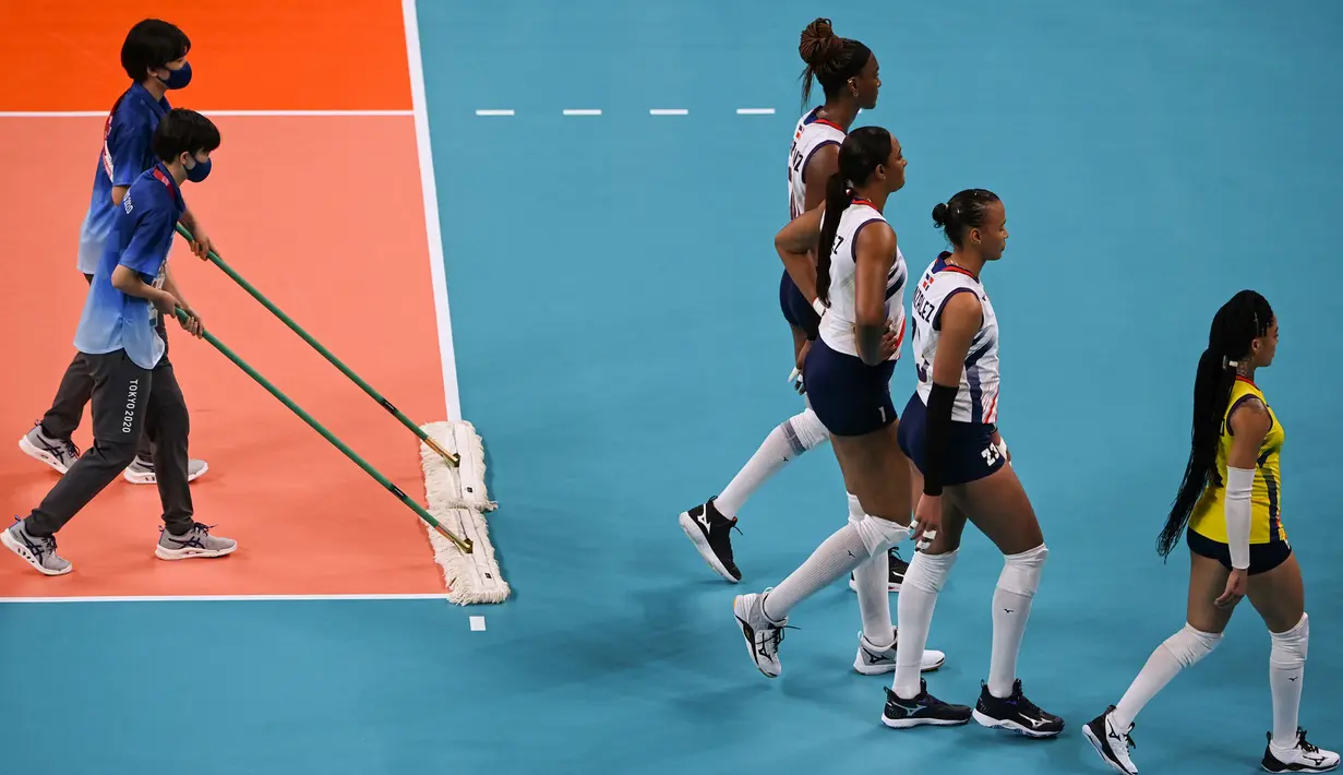 Relawan membersihkan lapangan saat babak penyisihan bola voli putri Olimpiade Tokyo 2020 antara Serbia dan Republik Dominika di Ariake Arena pada 25 Juli 2021. Relawan atau volunteer merupakan salah satu kunci suksesnya suatu perhelatan, tak terkecuali Olimpiade Tokyo 2020 ini. (YURI CORTEZ/AFP)
