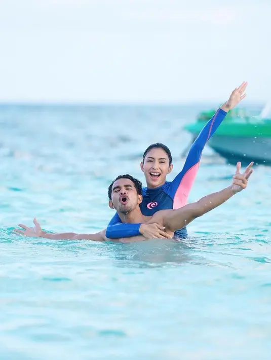 Tyas Mirasih dan Tengku Tezi tak hanya menghabiskan waktu di pinggir pantai. Mereka pun menikmati dinginnya air laut dengan berenang. Keduanya tetap terlihat mesra. (Foto: Instagram/@tyasmirasih)