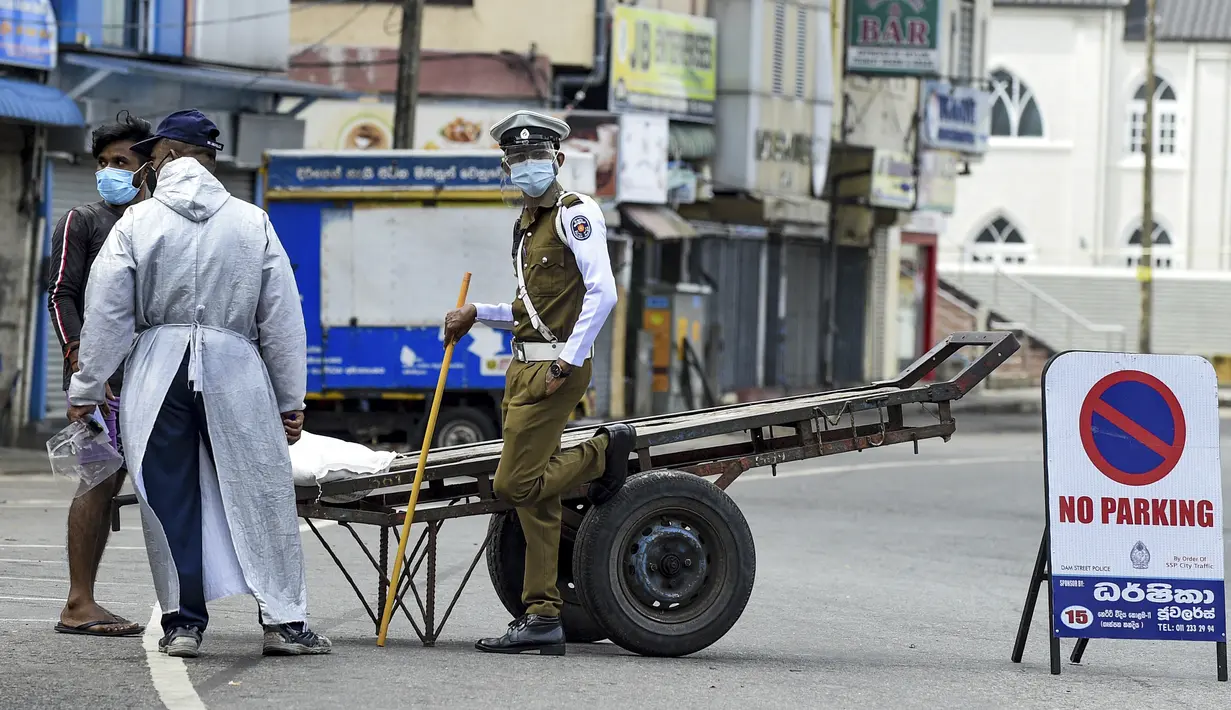 Aparat kepolisian memeriksa seorang warga yang tetap beraktivitas di luar rumah selama penerapan lockdown di Kolombo, Sri Lanka, Sabtu (21/8/2021). Rata-rata kasus harian Covid-19 di Sri Lanka kini mencapai 4.792 orang, melonjak lebih dari dua kali lipat dalam sebulan terakhir. (AFP/Ishara S. Kodika