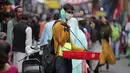 Seorang penjual yang mengenakan masker menjual barang antik di Sunday market di Jammu, India, Minggu (21/3/2021). India sedang menghadapi gelombang baru infeksi Covid-19 dan mencatat rekor lonjakan harian tertinggi dalam hampir empat bulan terakhir. (AP Photo/Channi Anand)