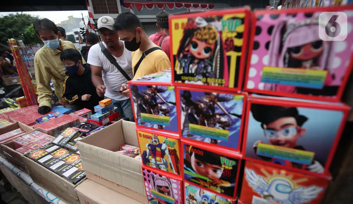Pedagang melayani pembeli kembang api di Pasar Asemka, Jakarta, Kamis (30/12/2021). Meski Larangan Tahun Baru 2022 diberlakukan untuk membatasi mobilitas, namun masih banyak warga yang berburu kembang api baik untuk dijual maupun digunakan sendiri. (Liputan6.com/Johan Tallo)