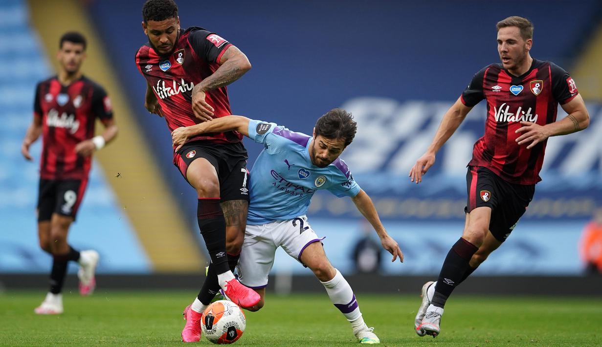 Gelandang Manchester City, Bernardo Silva, berebut bola dengan striker Bournemouth, Joshua King, pada laga lanjutan Premier League pekan ke-36 di Etihad Stadium, Kamis (16/7/2020) dini hari WIB. Manchester City menang 2-1 atas Bournemouth. (AFP/Dave Thompson/pool)