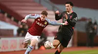 Striker Aston Villa, Louie Barry (kiri) berebut bola dengan gelandang Liverpool, Curtis Jones dalam laga babak ke-3 Piala FA 2020/21 di Villa Park, Birmingham, Jumat (8/1/2021). Aston Villa kalah 1-4 dari Liverpool. (AFP/Hannah McKay/Pool)