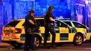 Polisi bersenjata mengamankan lokasi ledakan usai konser penyanyi Ariana Grande di Manchester Arena, Inggris, Senin (22/5). Ledakan yang menewaskan 19 orang itu terjadi sesaat setelah Ariana Grande selesai mengadakan pertunjukan. (Peter Byrne/PA via AP)