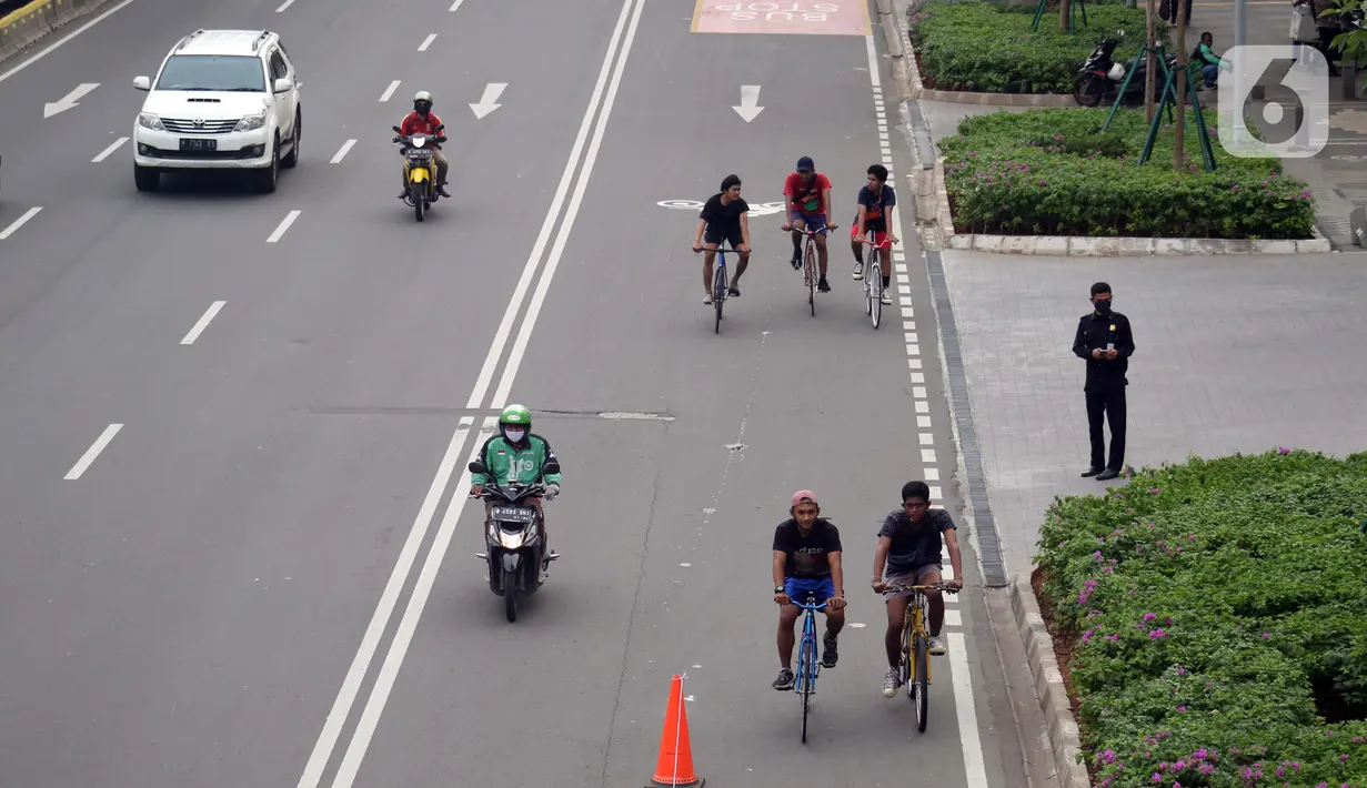 Pesepeda melintasi Jalan Jenderal Sudirman, Jakarta, Kamis (9/7/2020). Berdasar data yang diumumkan pemerintah pada Kamis (9/7) ada penambahan 2.657 orang yang terinfeksi COVID-19 sehingga jumlah penderita menjadi 70.736. (Liputan6.com/Helmi Fithriansyah)