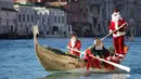Seorang anak mengenakan kostum Santa Claus mendayung perahu di Canal Grande di Venesia, Italia, (17/12). Sekitar dua ratus pendayung memberikan kehidupan pada prosesi air tradisional Santa Claus. (Andrea Merola / ANSA via AP)