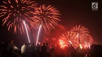 Pengunjung menyaksikan pesta kembang api saat malam Tahun Baru 2019 di Pantai Lagoon, Ancol, Jakarta, Selasa (1/1). Ancol menyajikan pesta kembang api musikal sepanjang 600 meter di bibir pantai dalam menyambut Tahun Baru 2019. (Merdeka.com/Iqbal Nugoho)