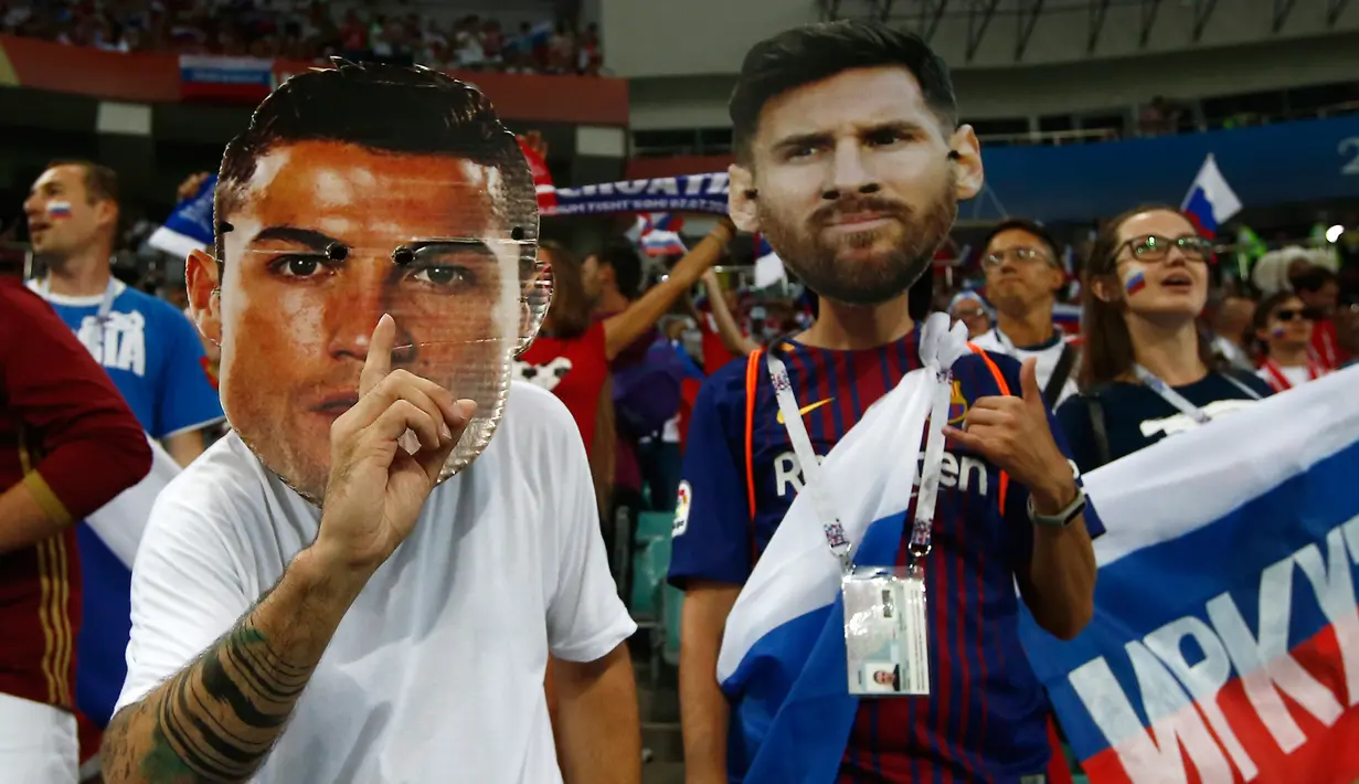 Suporter mengenakan topeng bintang Portugal, Cristiano Ronaldo dan bintang Argentina, Lionel Messi sebelum laga babak perempat final Piala Dunia 2018 antara Rusia dan Kroasia di Stadion Olimpiade Fisht, Sochi, Sabtu (7/7). (AP Photo/Manu Fernandez)