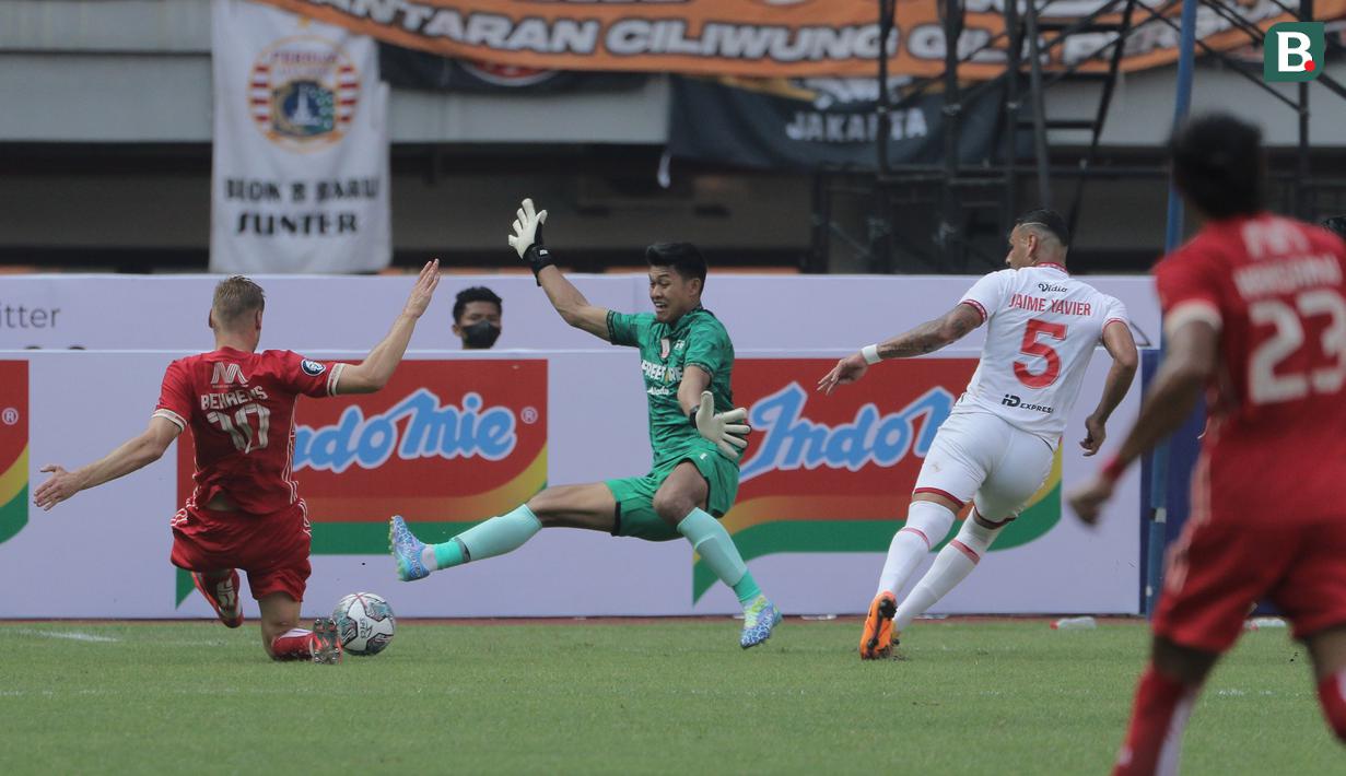 <p>Kiper Persis Solo, Muhammad Riyandi (tengah) berusaha memotong bola yang dilepaskan pemain Persija Jakarta, Hanno Behrens dalam laga pekan ke-2 BRI Liga 1 2022/2023 antara Persija Jakarta melawan Persis Solo di Stadion Patriot Candrabhaga, Bekasi, Minggu (31/7/2022) sore WIB. (Bola.com/Ikhwan Yanuar)</p>
