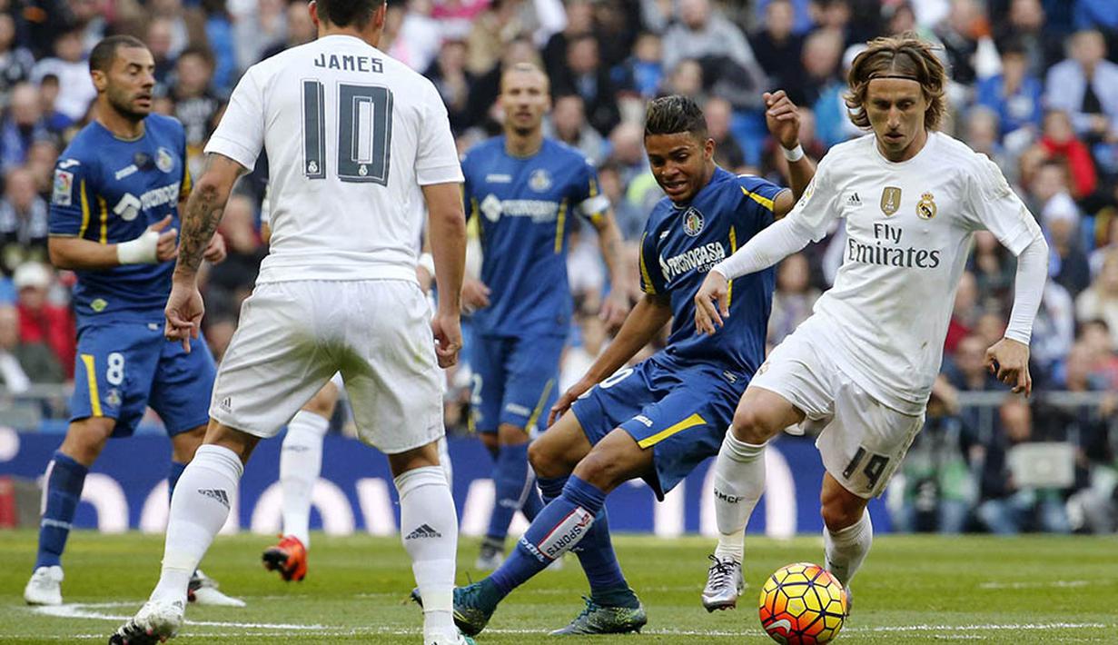 Gelandang Real Madrid, Luka Modric, berusaha melwati pemain Getafe, Wanderson, pada laga La Liga di Stadion Santiago Bernabeu, Spanyol, Sabtu (5/12/2015). (EPA/Zipi)