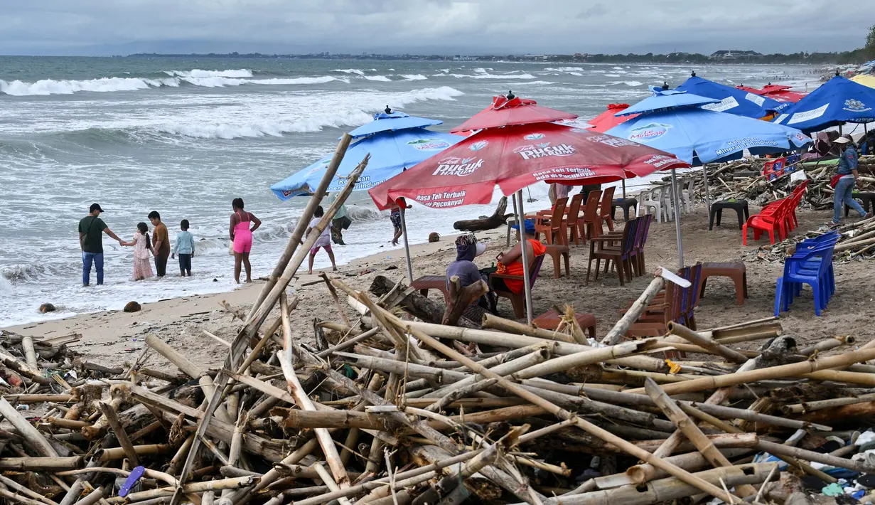 Fenomena ini terjadi akibat angin barat yang membawa sampah dari lautan menuju kawasan pantai. (SONNY TUMBELAKA/AFP)