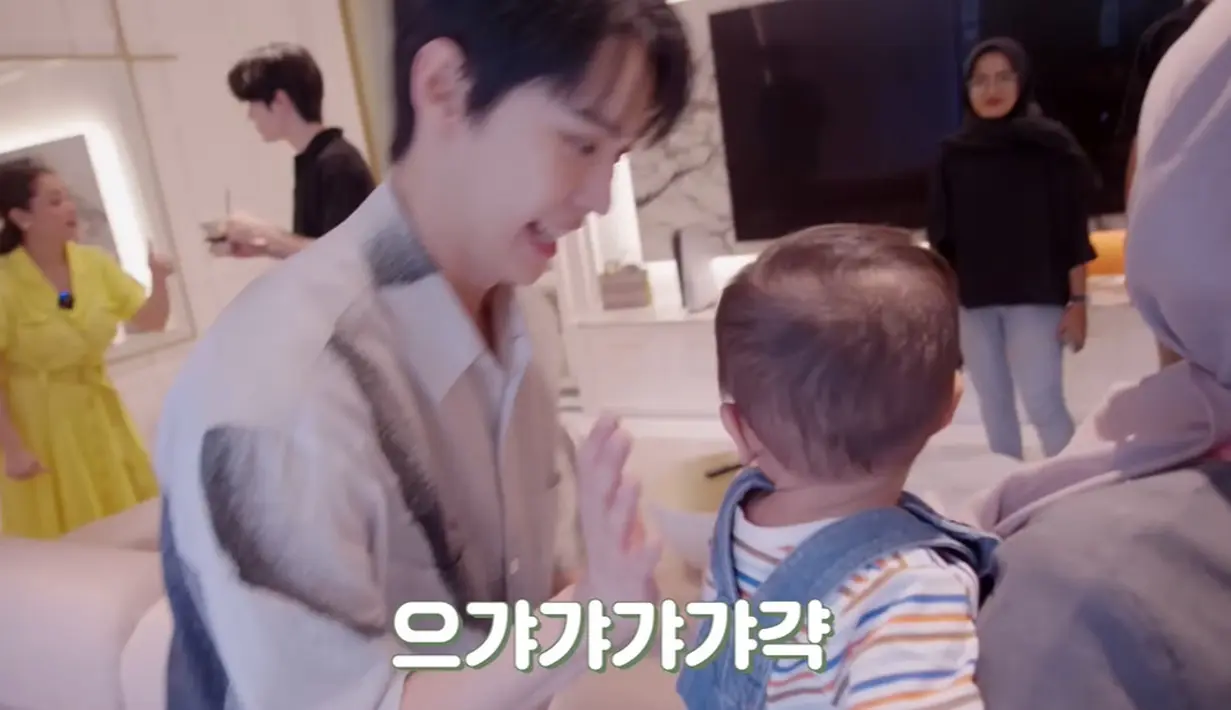 Saat Cipung sedang dalam gendongan pengasuhnya, Doyoung juga terus menggodanya. Dia berlari kecil ke arah Cipung dan membuat gestur menggemaskan. (Foto: YouTube/ NCT)