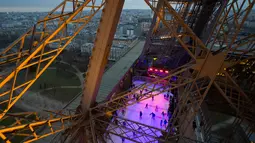 Wisatawan menikmati arena seluncur es yang dibuka di lantai 1 Menara Eiffel, Paris, 19 Desember 2016. Arena ice skating ini bisa dinikmati secara gratis hanya dengan membeli tiket kunjungan Eiffel seharga €9 atau sekitar Rp 139 ribu (AFP PHOTO/JOEL SAGET)