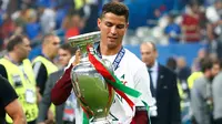 Cristiano Ronaldo membawa tropi Piala Eropa 2016 usai mengalahkan Prancis 1-0 di Stade de France, Senin (11/7). Ronaldo melesakkan gol paling banyak di EURO 2016 sebanyak 29 gol. Gol tersebut dihitung sejak babak kualifikasi. (REUTERS)