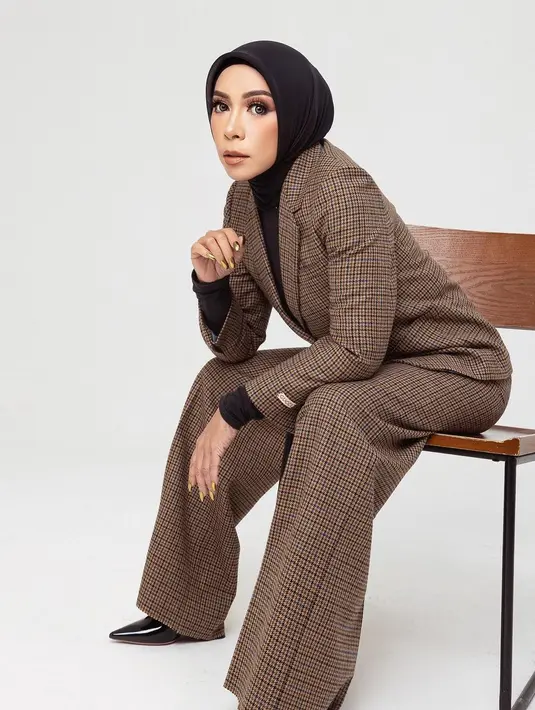 Tak beda jauh dengan Mulan. Untuk bergaya formal, blazer kerap jadi andalan Melly Goeslaw. Pada potret ini, ia tampil stylish dengan set blazer motif gingham warna cokelat. [@melly_goeslaw]
