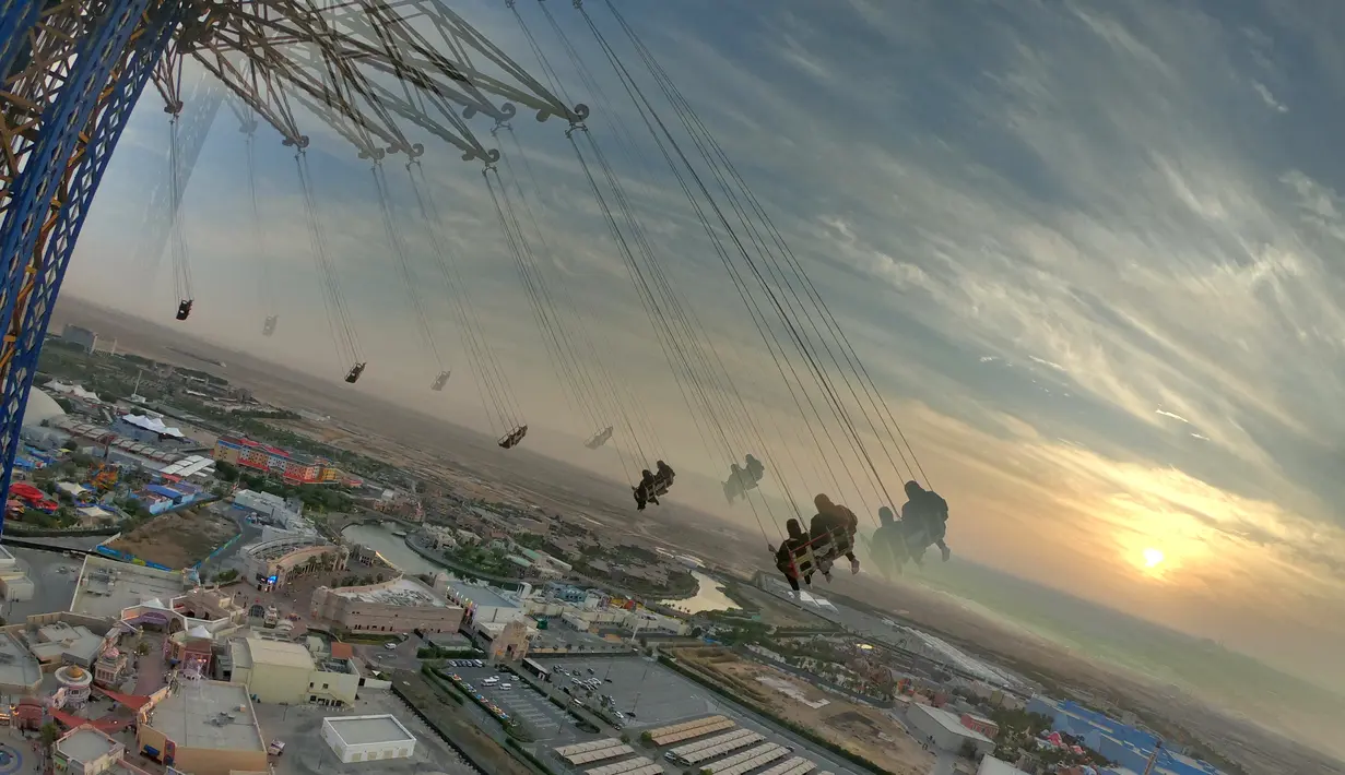 Orang-orang menaiki sky flyer di Taman Bollywood di Dubai (18/2/2021). Menjulang hingga 140 meter, Sky Flyer di Taman Bollywood, Dubai, memecahkan rekor dunia sebagai ayunan tertinggi dunia. (AFP/ Giuseppe Cacae)