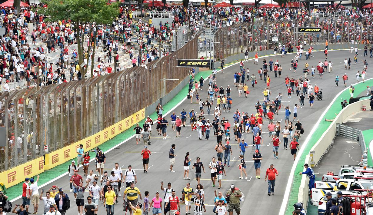 Para penonton memadati lintasan Sirkuit Interlagos, Sao Paulo, Brasil, jelang penghormatan juara di atas podium, Senin (16/11/2015) dini hari WIB. (AFP Photo/ Nelson Almeida)
