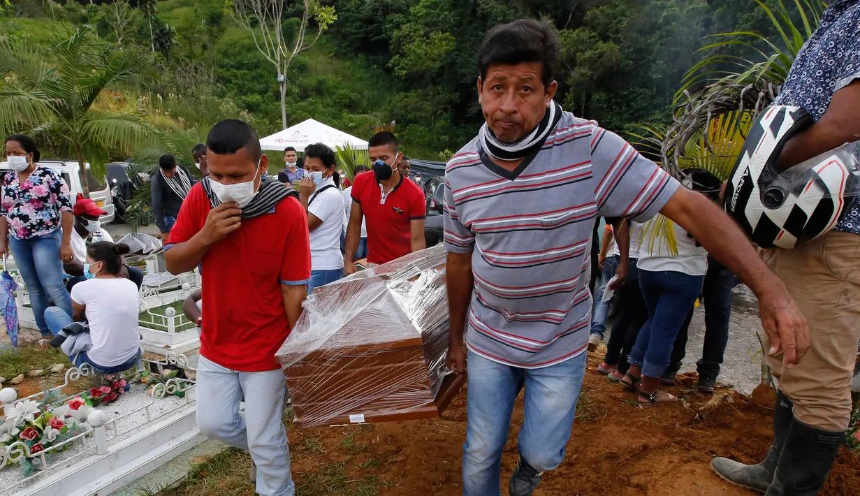 Warga membawa peti jenazah korban banjir dan tanah longsor sebelum dimakamkan di Mocoa, Kolombia, (3/4). Bencana tanah longsor tersebut disebabkan hujan deras yang terus mengguyur sejumlah kawasan di Kolombia. (AP Photo / Fernando Vergara)