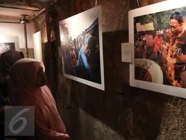 Pengunjung mengamati foto saat pameran foto Anugerah Pewarta Foto Indonesia (APFI) ke-VI di Gedung Bandung, Sabtu (9/4). APFI 2016 memamerkan 25 foto tunggal dan tiga foto seri terbaik sepanjang tahun 2015. (Liputan6.com/Faizal Fanani)