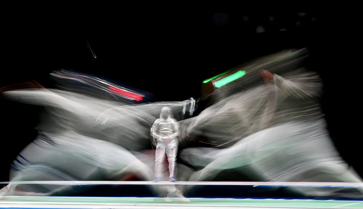 Atlet Anggar dari Italia, Luca Curatoli (kiri) bertanding melawan Iulian Teodosiu dari Rumania dalam pertarungan kualifikasi individu dalam ajang Olimpiade Tokyo 2020 di Makuhari Messe Hall, Jepang pada 24 Juli 2021. (AFP/Mohd Rasfan)
