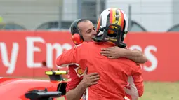 Pebalap Ferrari, Sebastian Vettel memeluk anggota timnya setelah finis di posisi terdepan dalam kualifikasi F1 GP di Sirkuit Hockenheim, Jerman, Sabtu (21/7). Vettel menorehkan waktu tercepat 1 menit 11,212 detik. (AP Photo/Jens Meyer)