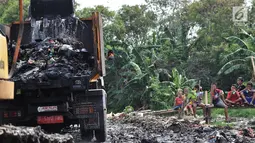 Anak-anak menyaksikan pengerukan sampah Kali Pisang Batu, Tarumajaya, Bekasi, Jawa Barat, Rabu (9/1). Petugas DLH Kabupaten Bekasi mulai membersihkan sampah setelah fenomena tersebut ramai diberitakan di media sosial. (Merdeka.com/Iqbal S. Nugroho)